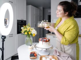 smiling vlogger showing delicious cakes while filming video